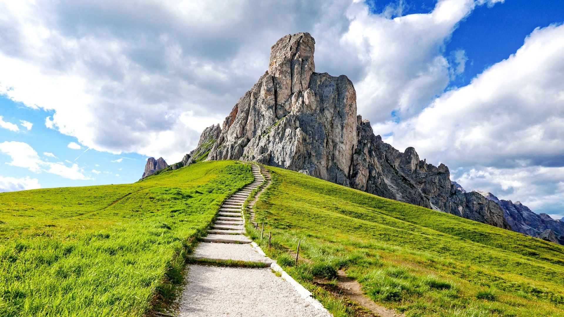 stairway-to-an-amazing-mountain-green-fields-and-gravel-path-with-stairs-leading-to-the-mountain_t20_lop6n8